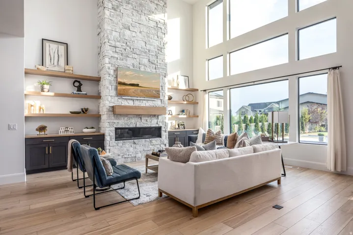 Spacious living area featuring a floor-to-ceiling stacked stone fireplace, a linear built-in fireplace, and a wood mantel