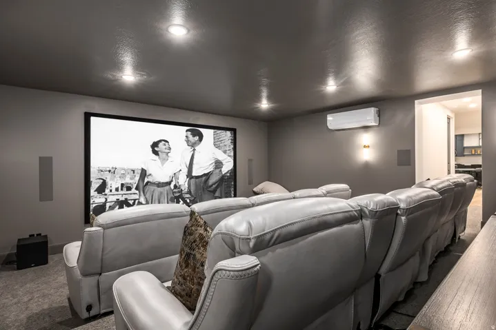 Dedicated media room featuring a large projection screen and built-in speakers