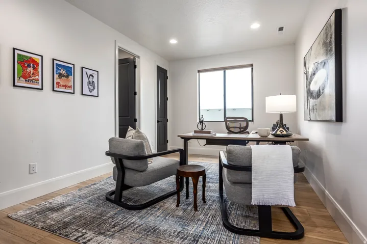 Bright room featuring wood-finish flooring, white walls, and a large window