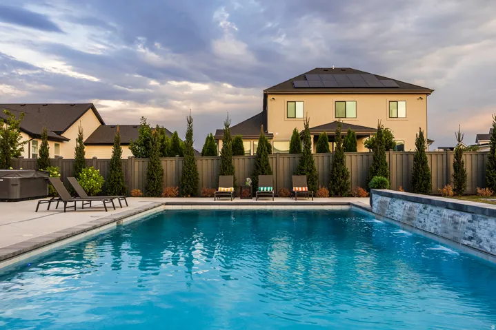 Rectangular inground swimming pool with a stone-clad waterfall feature