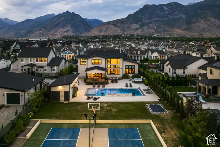 Contemporary residence featuring an expansive backyard with a multi-sport court, in-ground trampoline, and a swimming pool