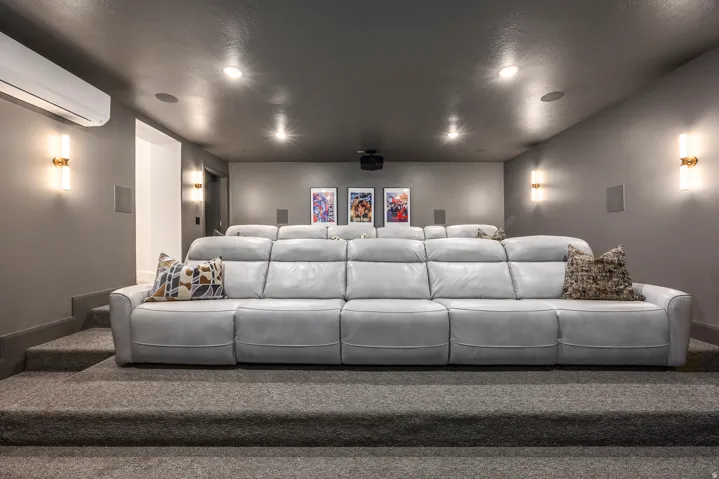 Dedicated media room featuring tiered seating platforms and dark gray carpeting