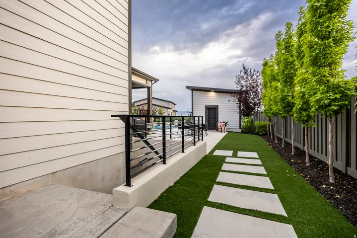 Manicured artificial turf lawn with concrete paver pathway