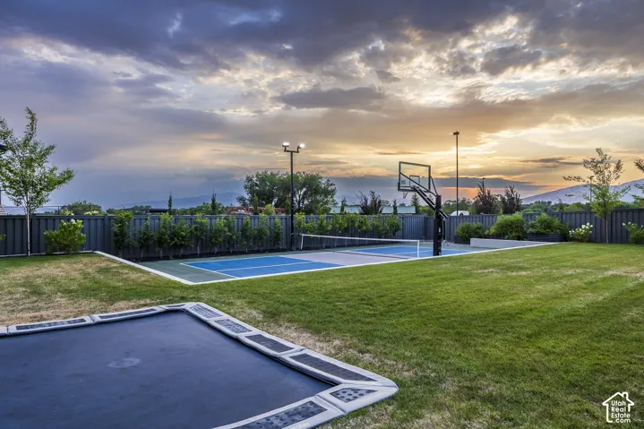 Manicured lawn area featuring an in-ground trampoline
