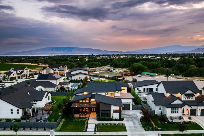 Contemporary residential property featuring a striking facade with mixed materials, an attached two-car garage, and a manicured front lawn