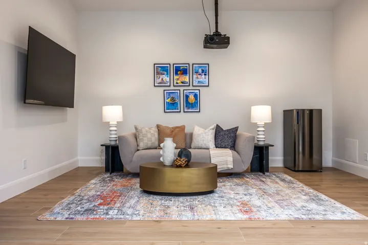 Entertainment space featuring light wood-finish flooring, white walls, and a recessed projector