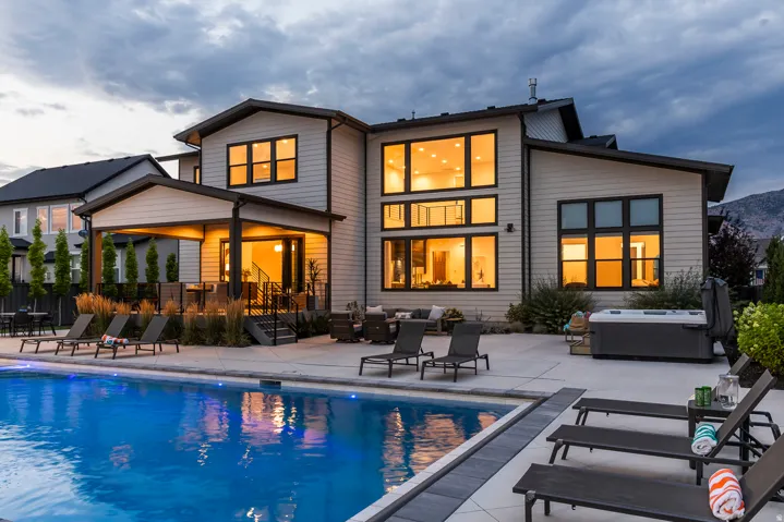 Modern multi-level residence featuring an inground swimming pool, expansive concrete patio, and a covered outdoor living area