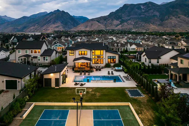 Contemporary residence featuring an expansive backyard with a multi-sport court, in-ground trampoline, and a swimming pool