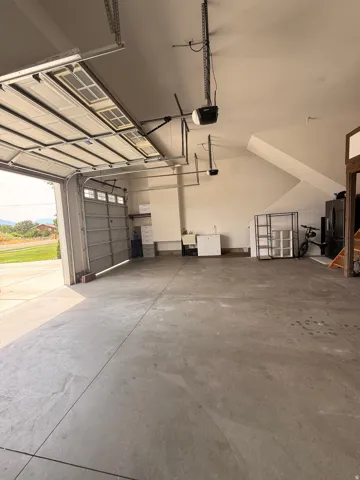 3 car Spacious garage featuring a concrete floor, 3 car garage with extra storage mezzanine