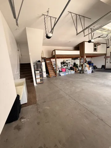 3 car Spacious garage featuring a concrete floor, 3 car garage with extra storage mezzanine