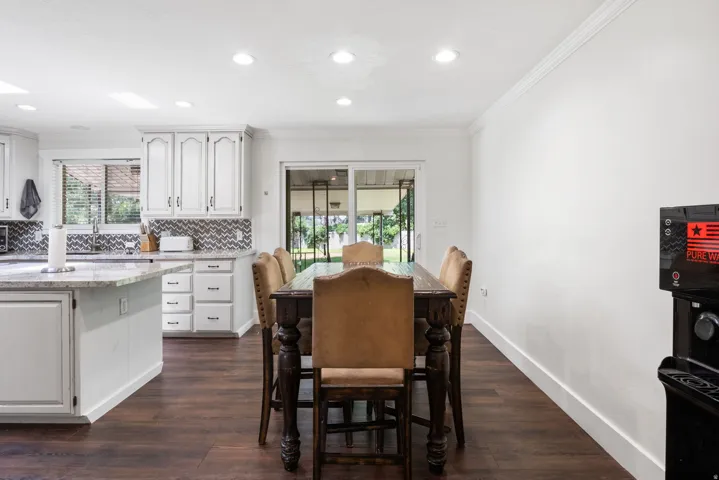 Open-concept kitchen and dining area featuring dark wood-finish flooring
