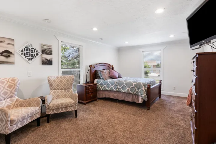 Bedroom with neutral-toned carpeting, white walls, and a white ceiling featuring recessed lighting