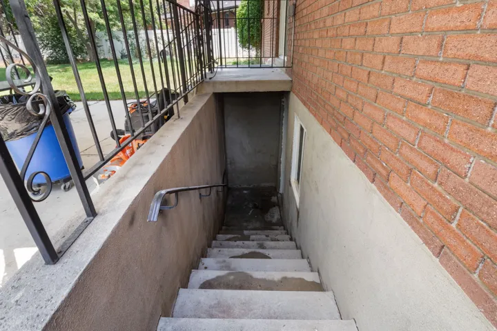 Concrete exterior staircase with a metal handrail and iron railing