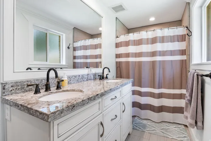 Double vanity featuring granite countertops and undermount sinks with oil-rubbed bronze fixtures