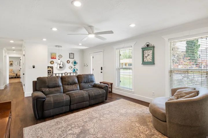 Open living area with wood-finish flooring, recessed lighting, and a ceiling fan