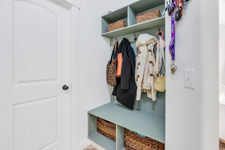 Built-in mudroom bench with coat hooks and overhead shelving