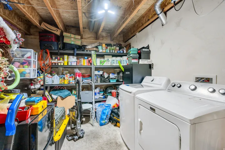 Utility area featuring exposed wood ceiling joists, concrete flooring, and an exposed ventilation duct