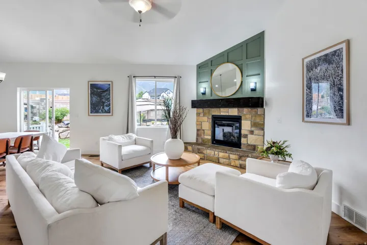 Stone fireplace with a black hearth and a dark wood mantel, featuring a paneled accent wall