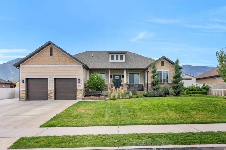 Contemporary ranch-style residence featuring a prominent two-car garage with dark wood-finish doors