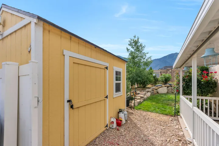Detached yellow storage shed with a single window and durable roofing