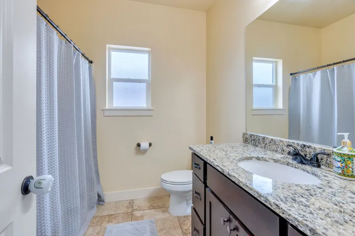 Bathroom vanity featuring a granite countertop, integrated sink, and dark wood cabinetry