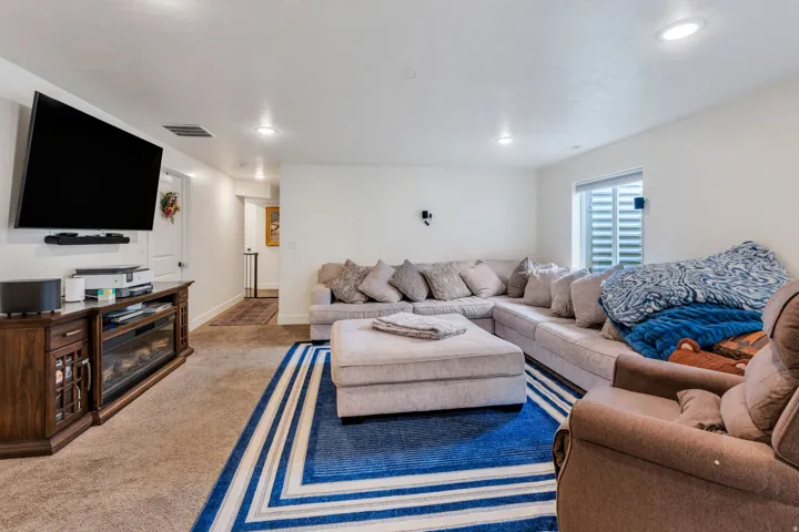 Carpeted living area featuring recessed lighting and a built-in media console with an electric fireplace