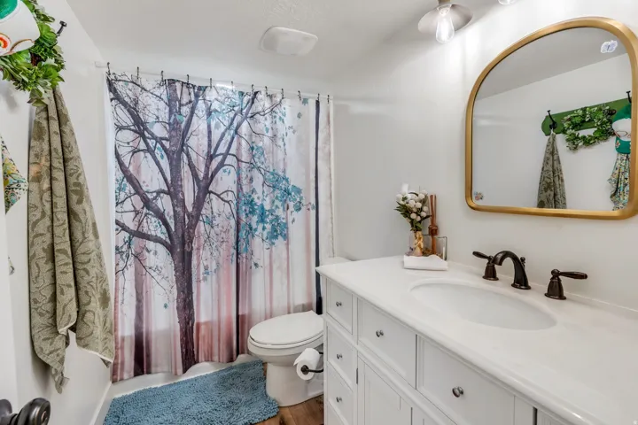 White vanity with ample counter space, integrated sink, and dark bronze-finish fixtures