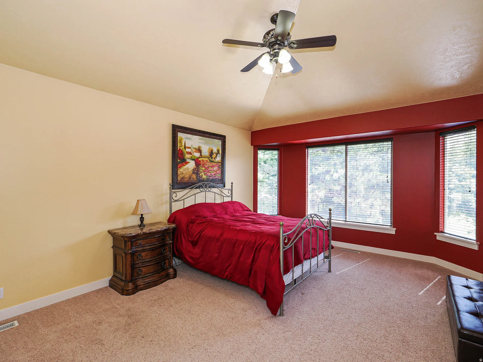 Bedroom featuring a vaulted ceiling, ceiling fan, and bay windows