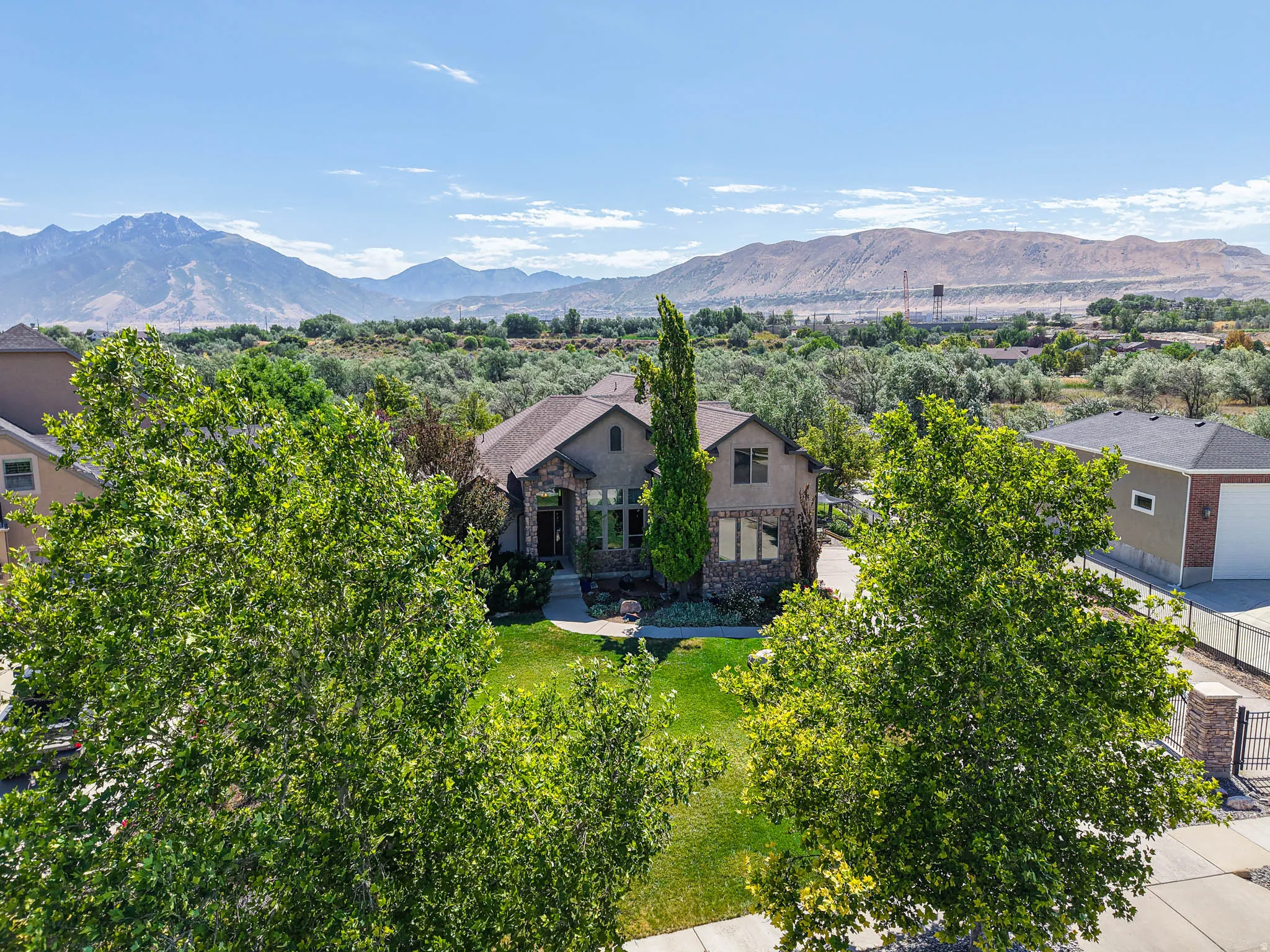 Stone and stucco exterior residence featuring a covered entry, gabled roofline, and attached garage