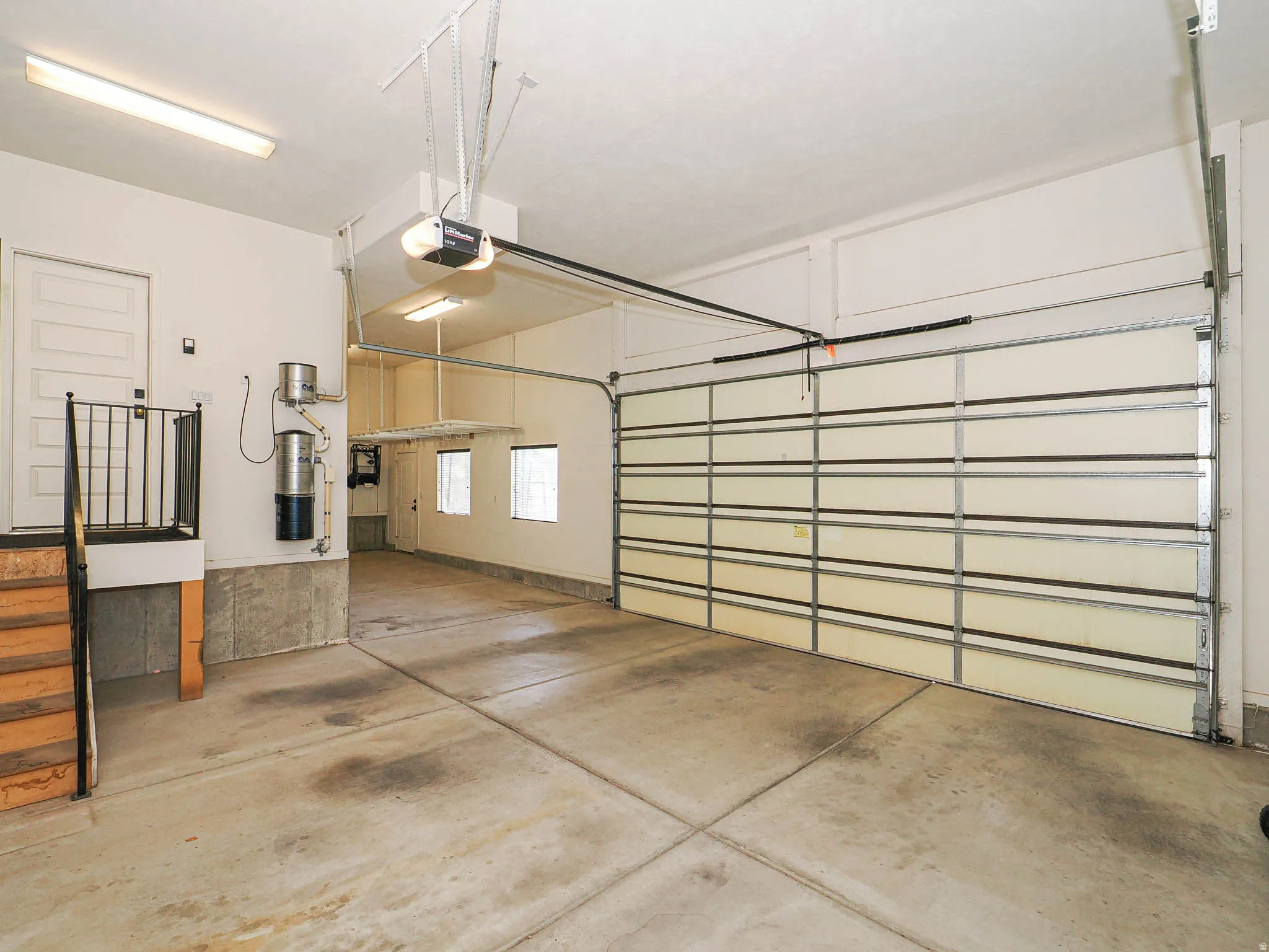 Spacious garage featuring a sectional garage door, concrete flooring, and an automatic garage door opener