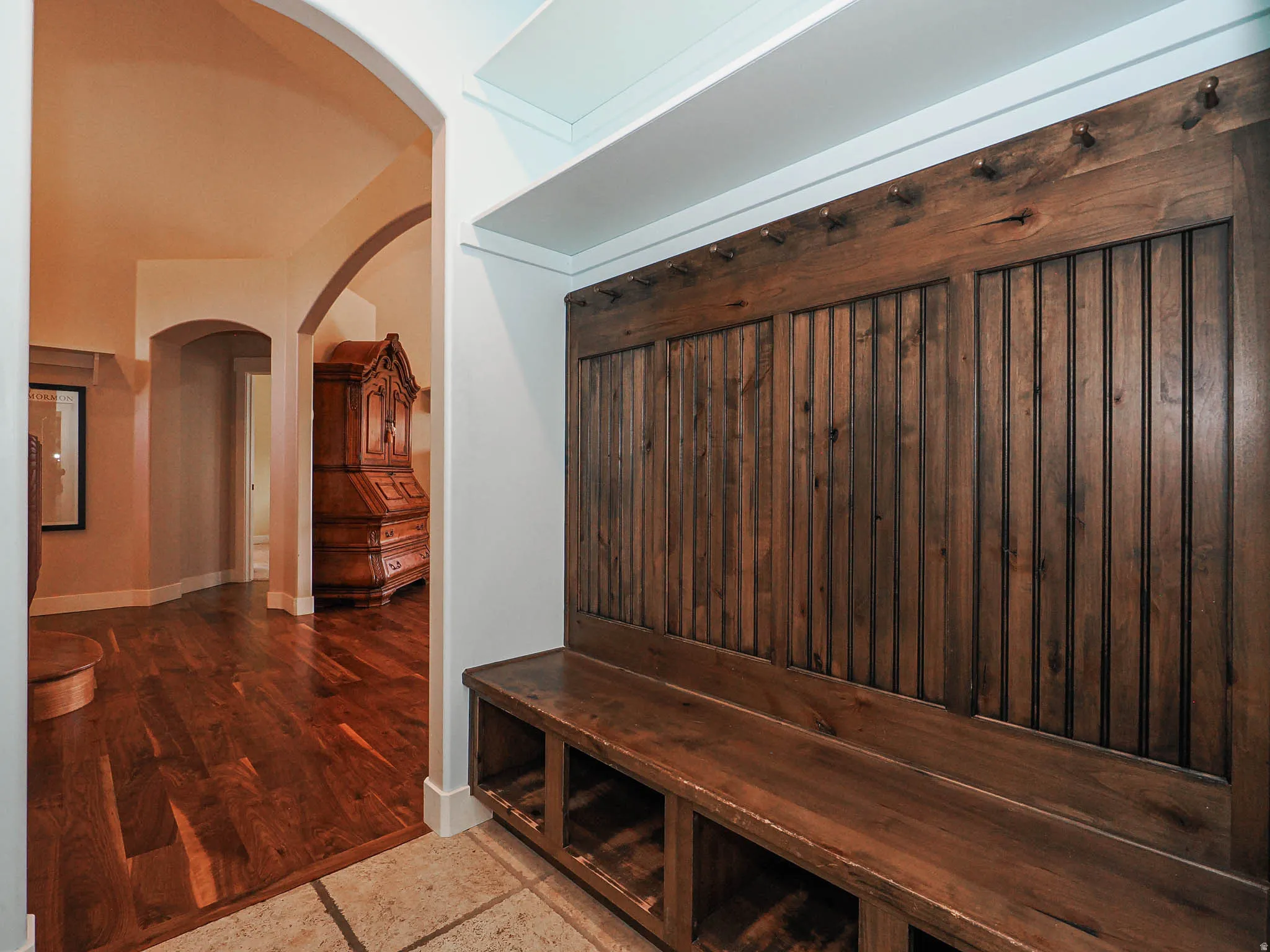 Built-in wood-finish bench with cubby storage and beadboard paneling