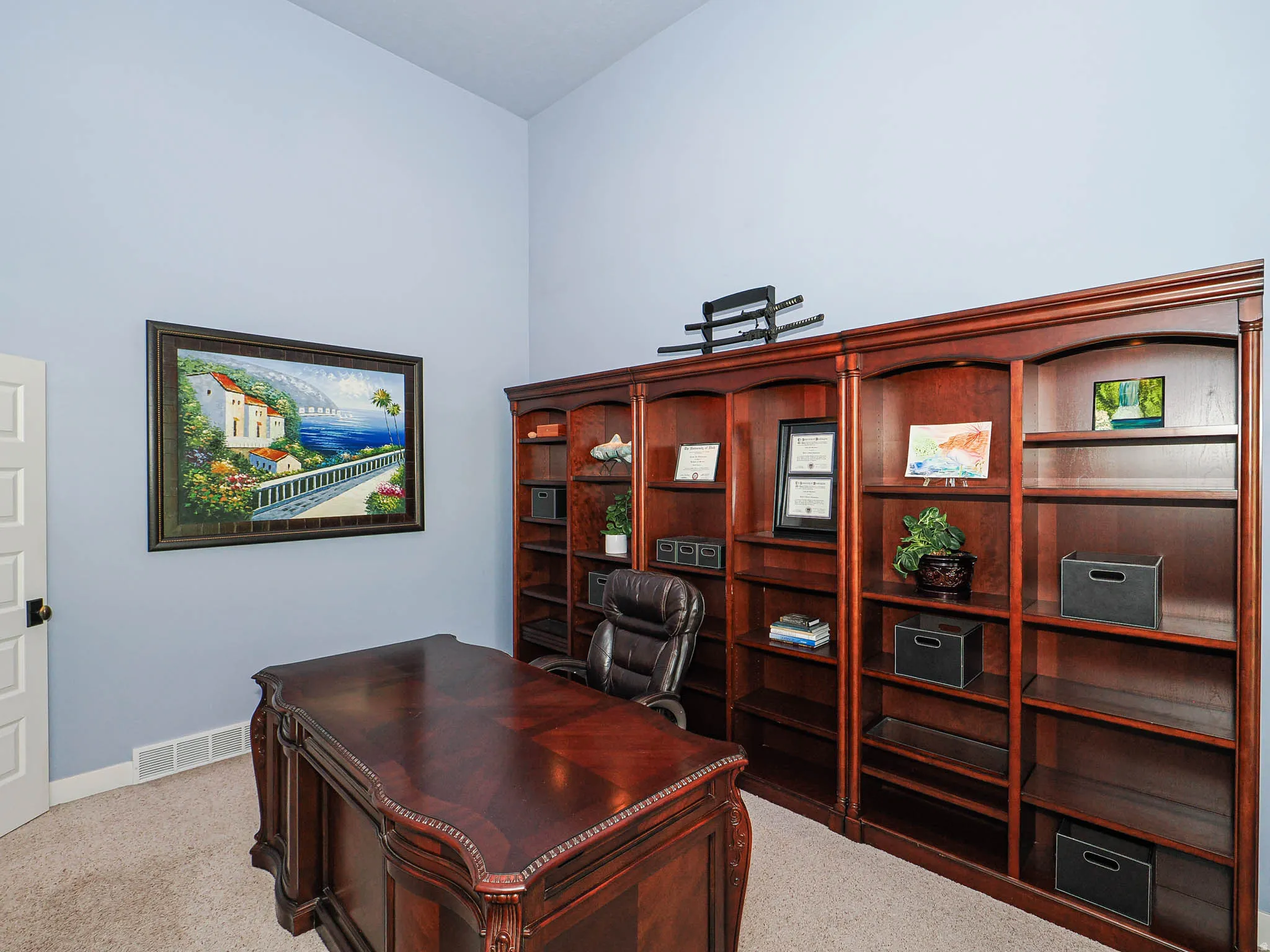 High ceilings define this room, featuring light blue walls and neutral carpet