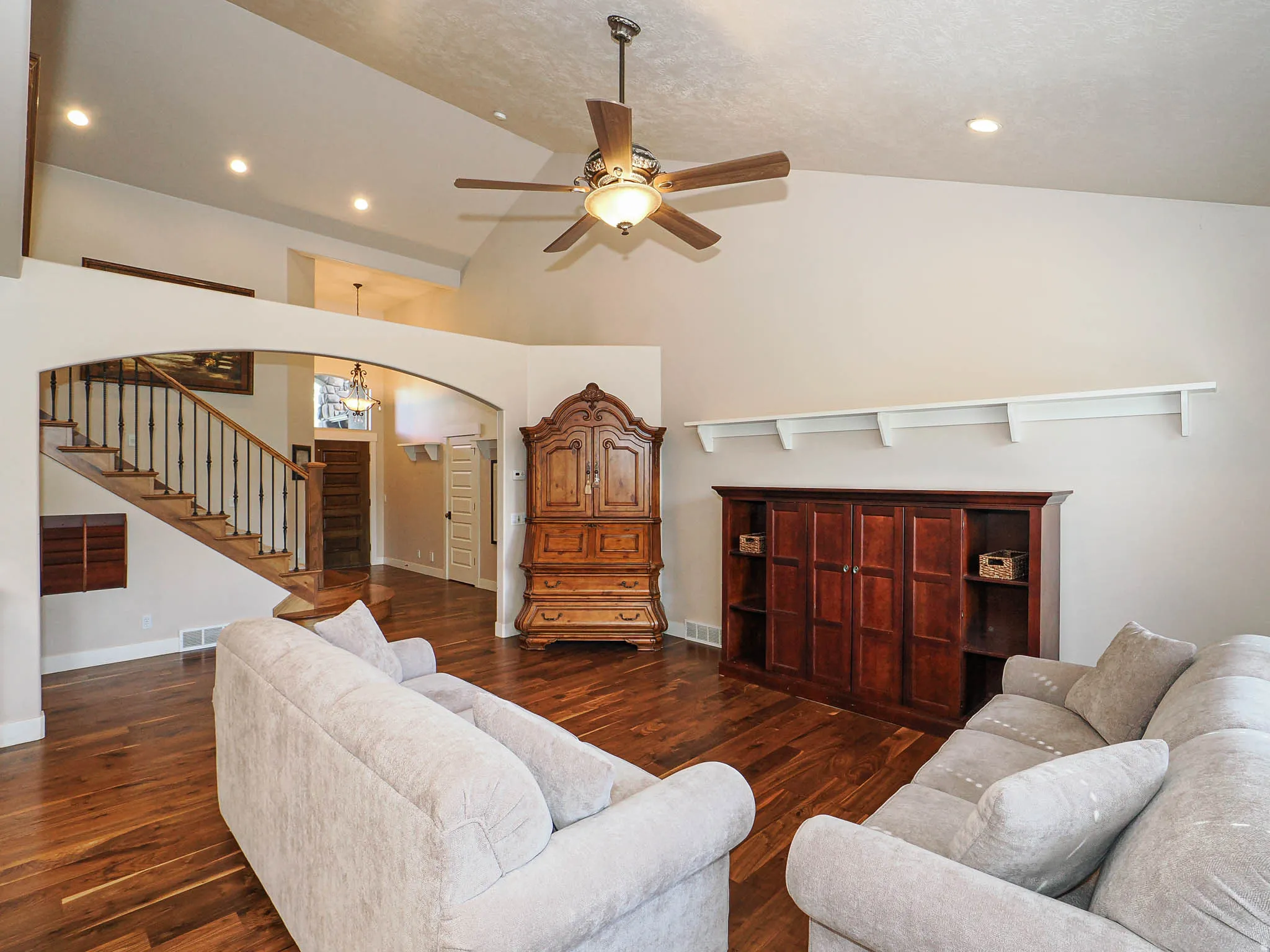 Living area featuring vaulted ceilings with recessed lighting, a ceiling fan, and rich wood-finish flooring