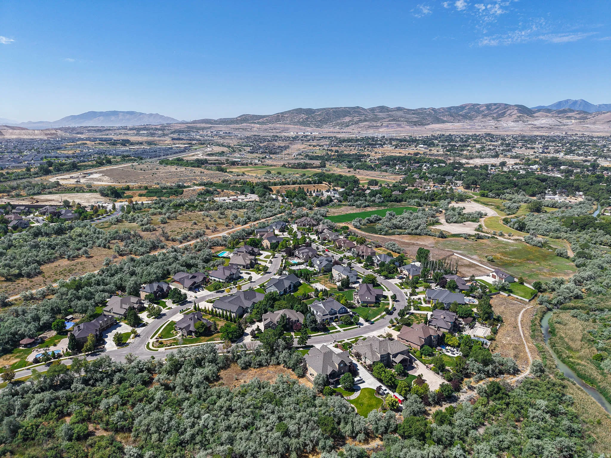 Aerial perspective showcasing a residential community with mature trees and a winding river