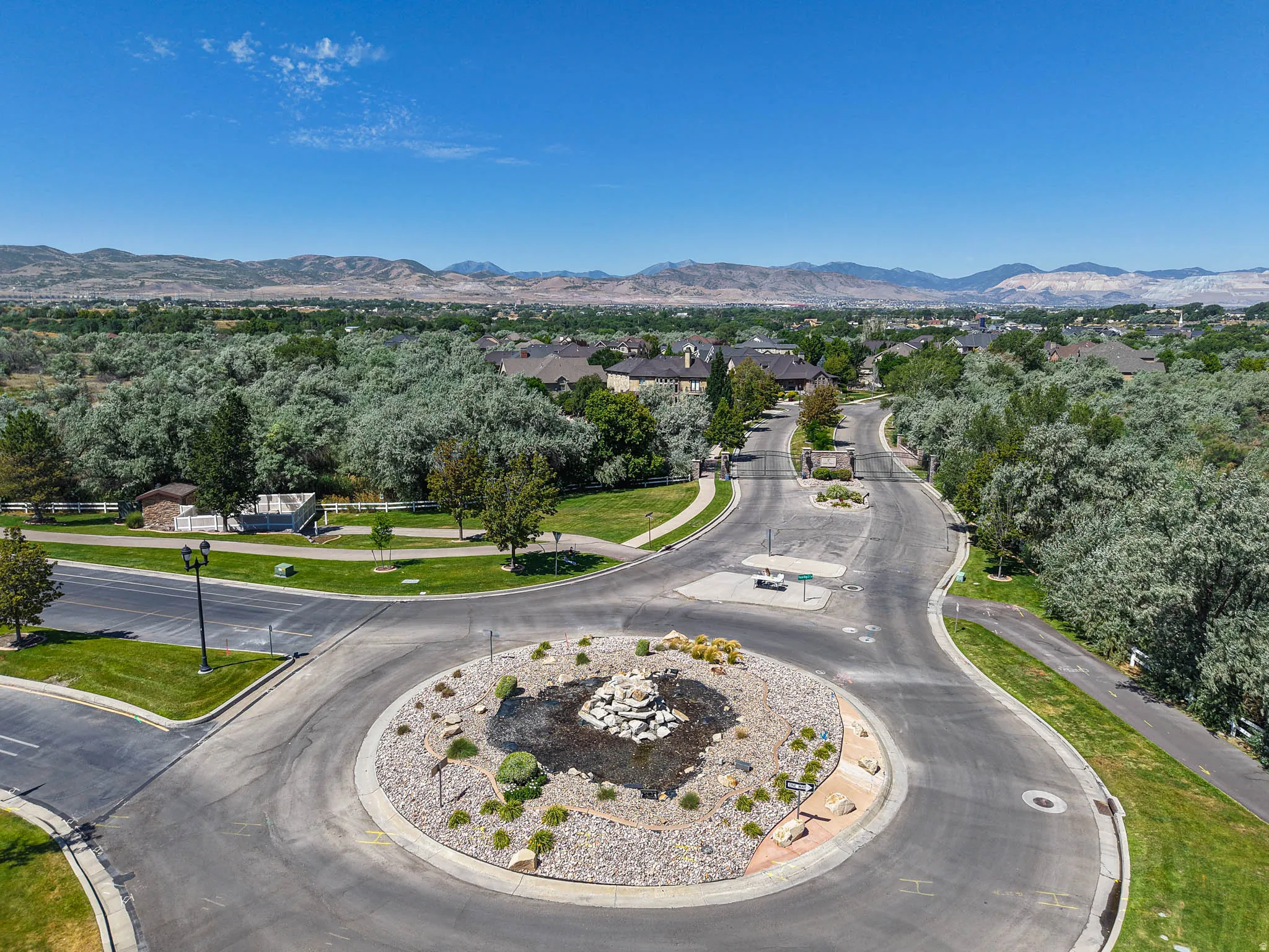 Roundabout entry featuring a rock-lined water feature