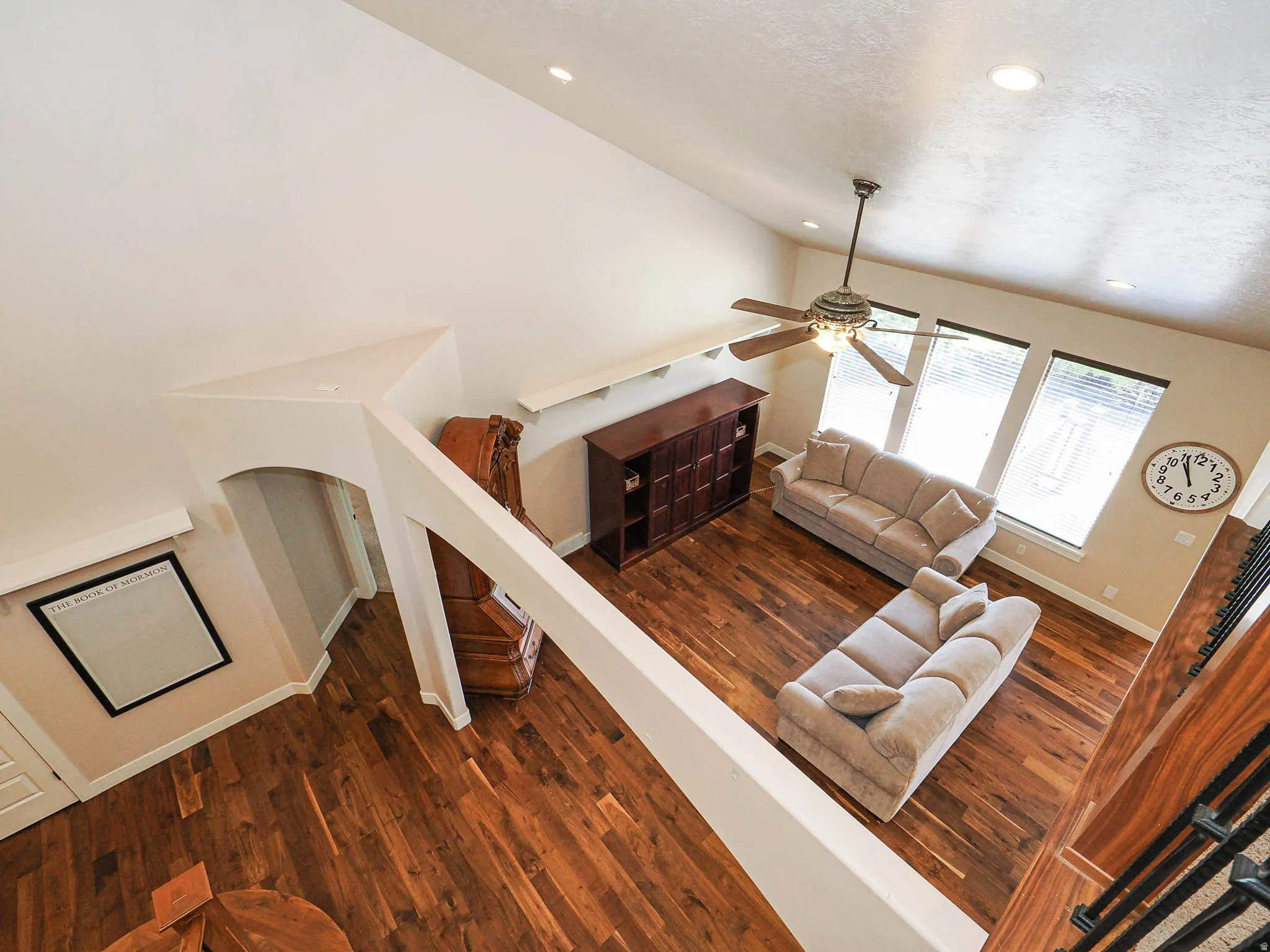 Spacious living area featuring vaulted ceilings, recessed lighting, and wood-finish flooring
