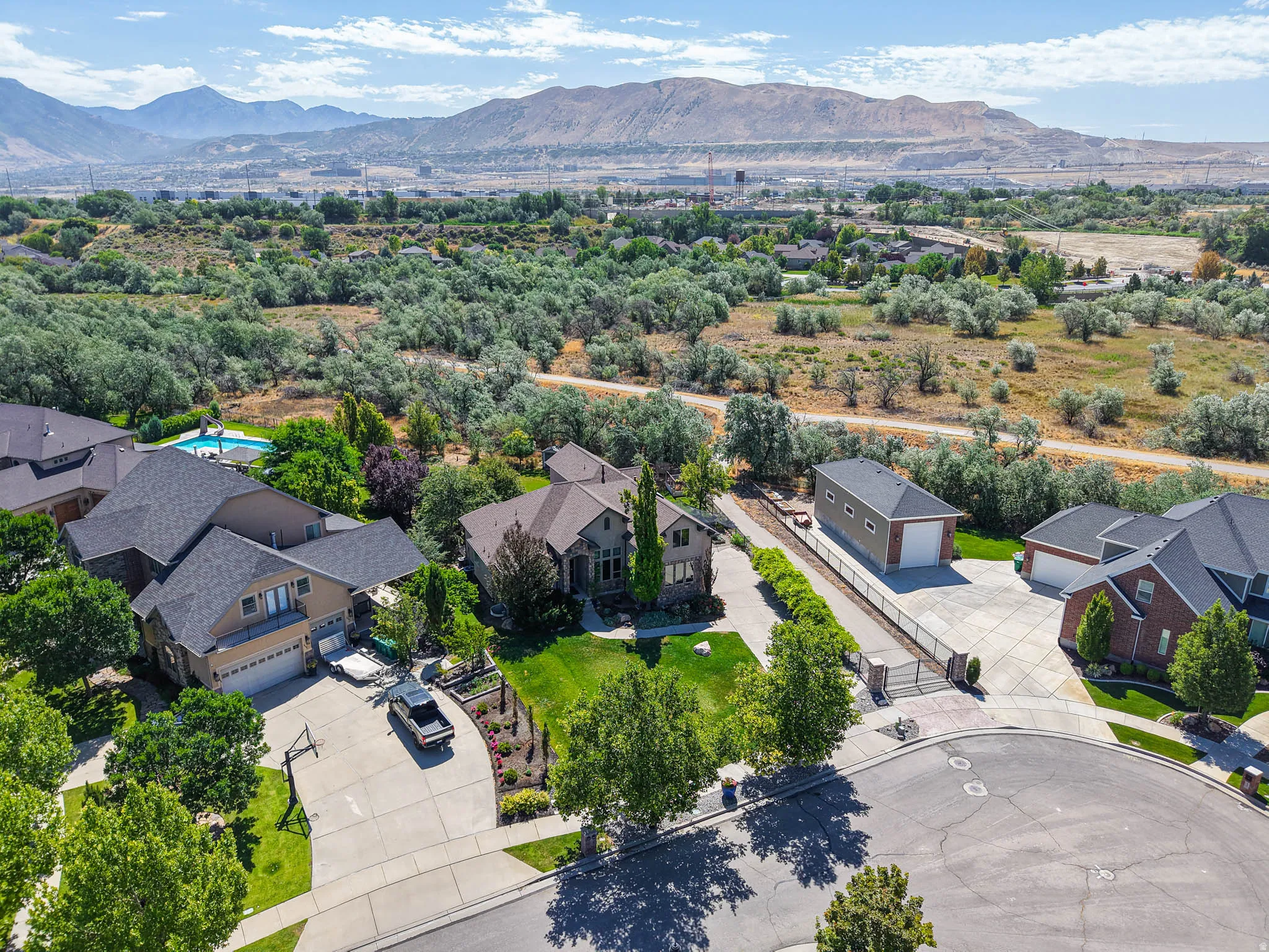 Expansive cul-de-sac property featuring a multi-story residence with an attached garage, a detached garage, and a gated entrance