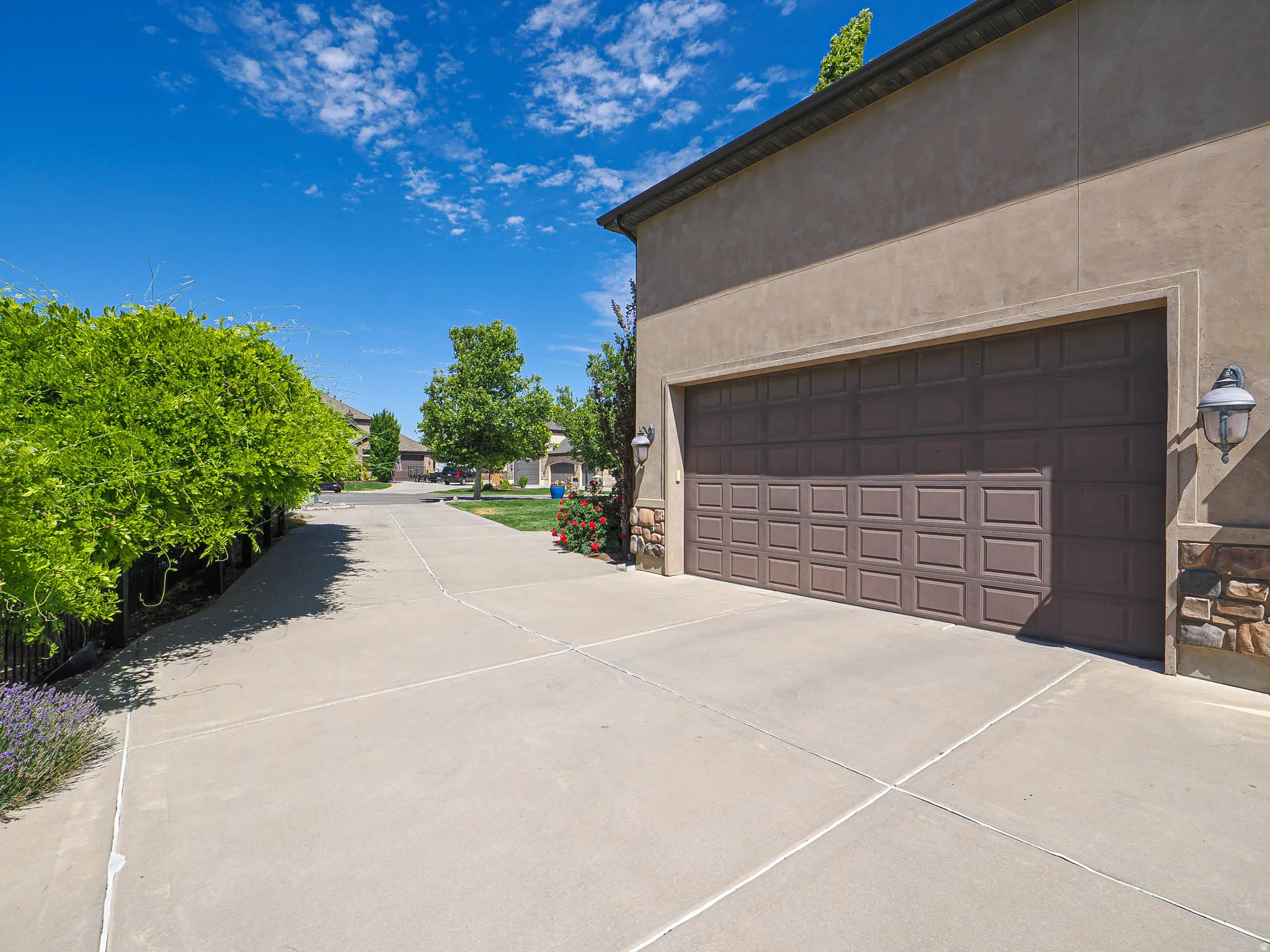 Garage exterior featuring a panel-style door, stucco siding, and stone accents