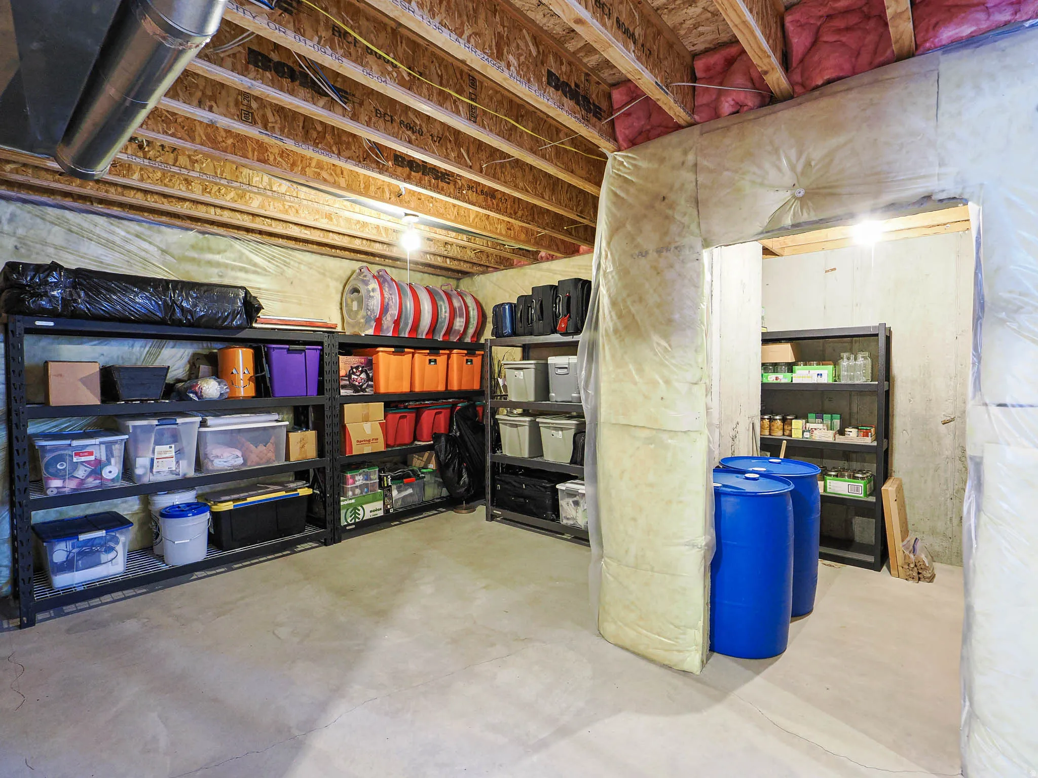 Unfinished basement featuring exposed joists, ductwork, and concrete flooring