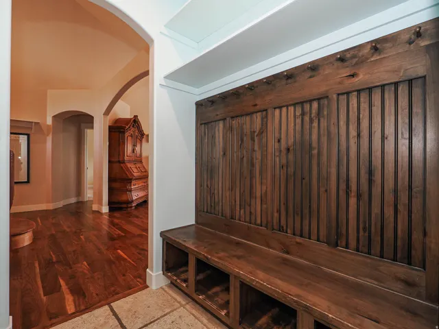 Built-in wood-finish bench with cubby storage and beadboard paneling