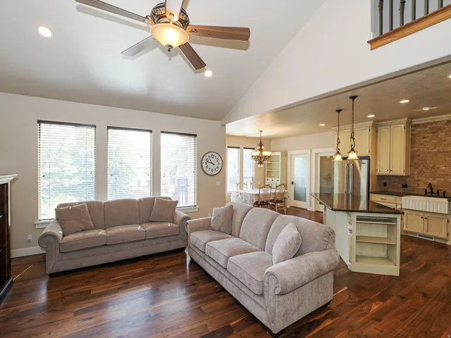 Spacious open-concept living area featuring high vaulted ceilings, recessed lighting, and wood-finish flooring