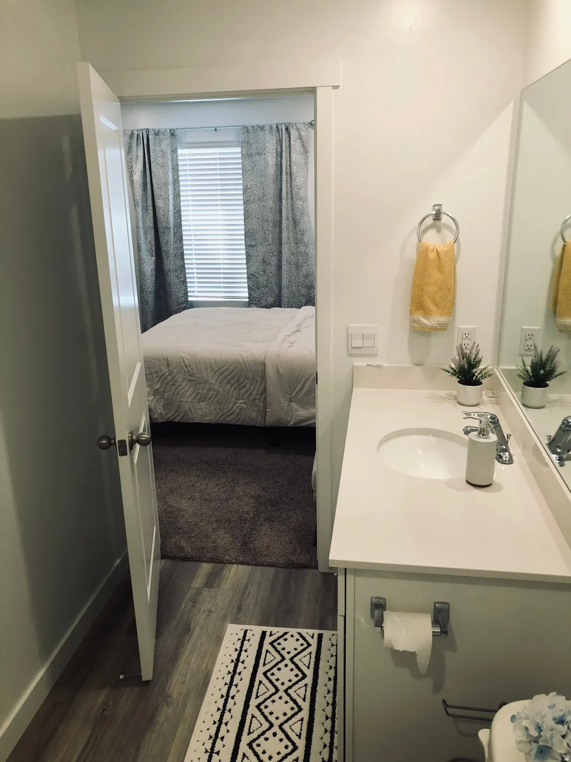 Bathroom featuring a single vanity with an integrated sink, polished chrome faucet, and a large wall mirror