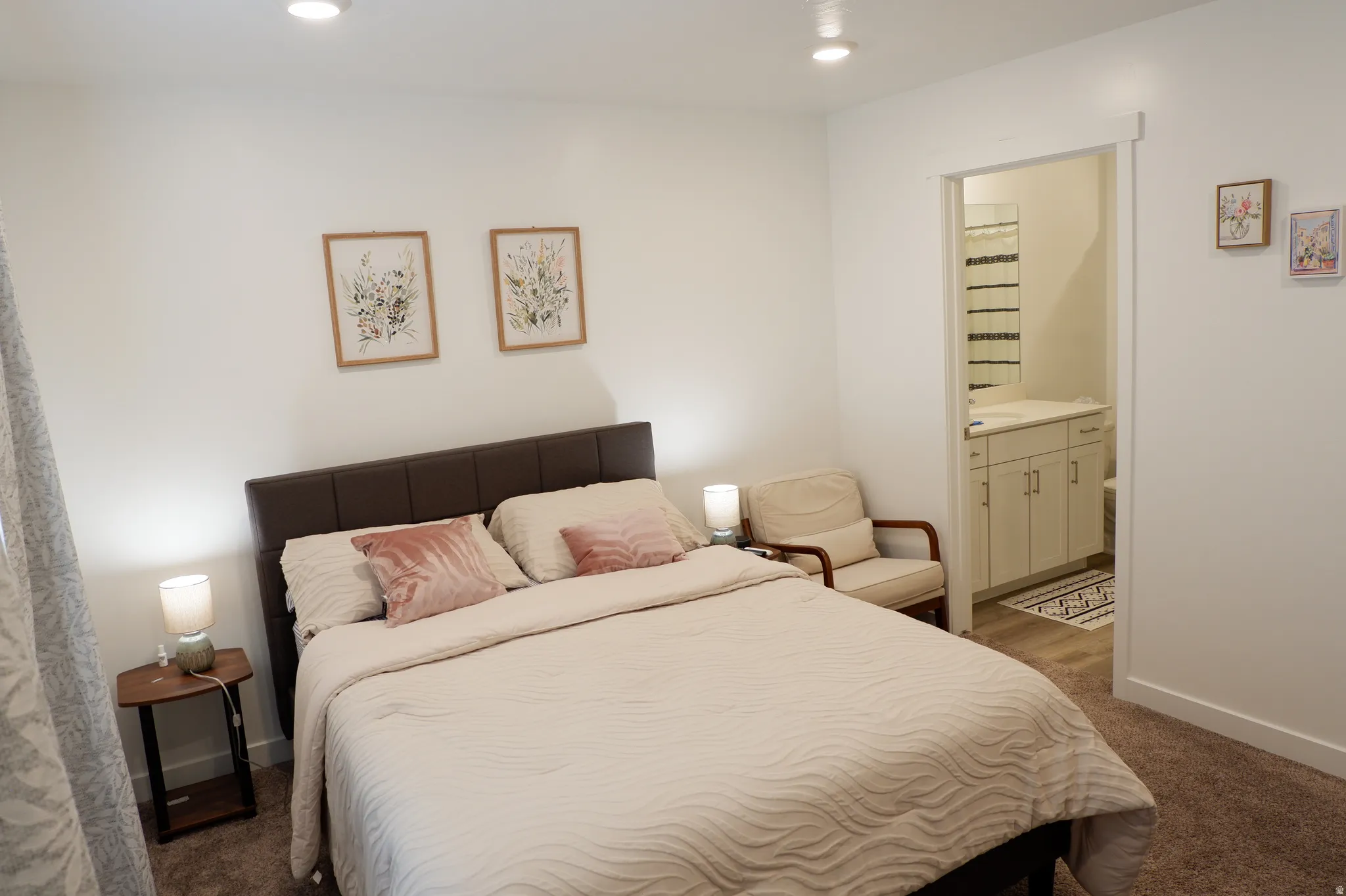 Bedroom with neutral carpeting, recessed lighting, and a brown upholstered headboard