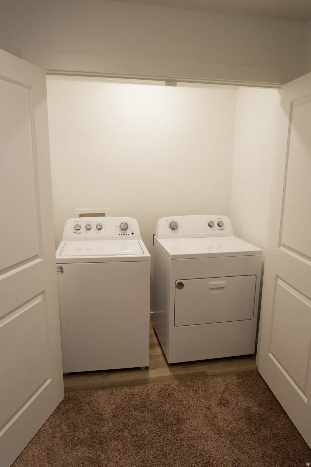 Dedicated laundry closet with wood-finish flooring