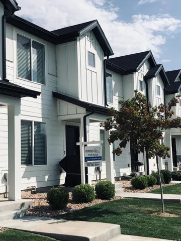 Contemporary townhome exterior featuring white siding and dark trim