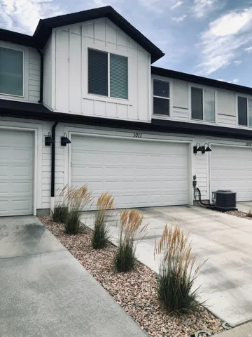 Modern townhome exterior with crisp white vertical siding and dark trim accents