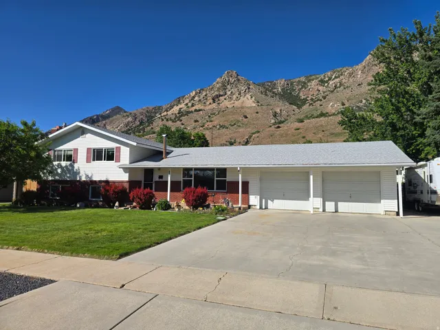 Split-level residence featuring a two-car garage and a paved driveway