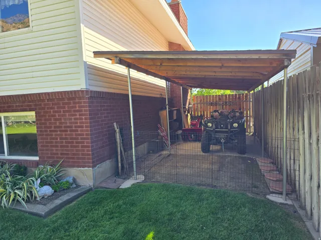 Carport structure featuring a wood-finish roof and metal support posts