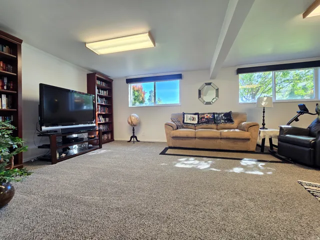 Spacious room featuring neutral carpeting, recessed ceiling lighting, and multiple windows providing natural light