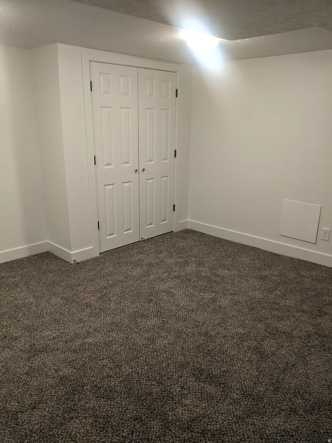Neutral-toned wall-to-wall carpeting complements the white walls and trim